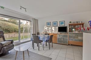 ein Wohnzimmer mit Tisch und Stühlen und einem Fernseher in der Unterkunft Peppino I - 10Gv01 G in Saint-Idesbald