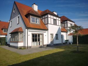 a large white house with an orange roof at Vlierhof in Sint-Idesbald