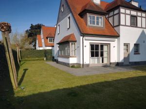 a large white house with a red roof at Vlierhof in Sint-Idesbald +6 photos