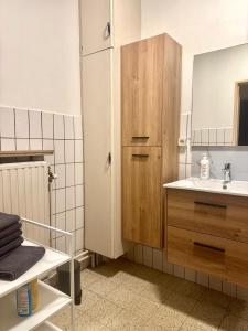 ein Badezimmer mit Waschbecken und einem Holzschrank in der Unterkunft Simon Apartment in Antwerpen