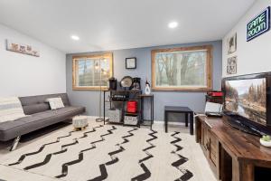 a living room with a couch and a tv at Creekside Cabin - Beaver Lake Creek Access in Rogers +20 photos