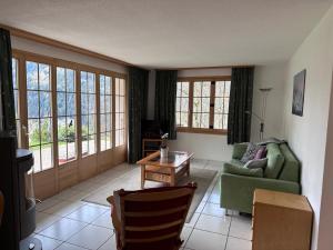 a living room with a green couch and a table at Chalet Panorama 1 in Wengen