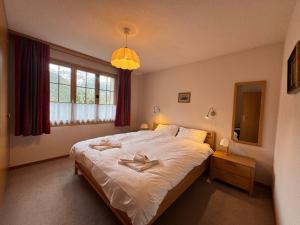 a bedroom with a bed with two towels on it at Chalet Panorama 1 in Wengen