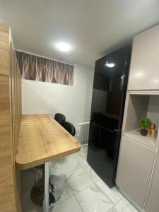 a kitchen with a wooden table and a refrigerator at Studio Moderne et Parking gratuit in Dijon