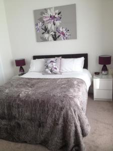 um quarto com uma cama grande e 2 candeeiros em Dunelm House em Seahouses