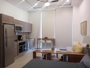 a kitchen with a refrigerator and a table in a room at Penthouse Studio 2 blocks from Los Muertos beach in Puerto Vallarta