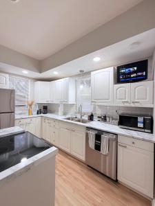 a large white kitchen with white cabinets and stainless steel appliances at Cornhusker Stadium Lodge in Lincoln