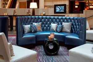 Un sofá azul en una sala de estar con una mesa. en Renaissance Atlanta Waverly Hotel & Convention Center, en Atlanta