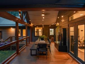 アッシュビルにあるLUXE, 2 miles to Downtown, Hot Tub, Fire Pit, Secluded Serenity of the Blue Ridge Mountainsのテーブルと椅子が置かれた網戸付きのポーチ