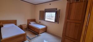 a small bedroom with two beds and a window at Appartement neuf centre ville de Tinghir in Tinerhir