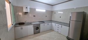 a kitchen with a refrigerator and a washing machine at Appartement neuf centre ville de Tinghir in Tinerhir