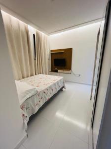 una piccola camera con letto e televisore di Sunset House - Casa de praia ad Aracaju Altre 4 foto