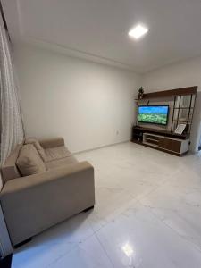 un soggiorno con divano e TV a schermo piatto di Sunset House - Casa de praia ad Aracaju
