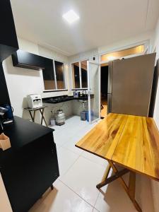 una cucina con tavolo in legno al centro di Sunset House - Casa de praia ad Aracaju