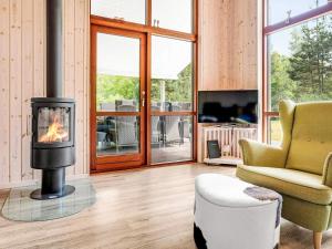 Una sala de estar con chimenea y una silla. en 5 star holiday home in Væggerløse, en Bøtø By