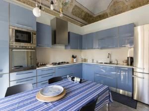 una cucina blu con tavolo e armadi blu di Loft Duca di Genova a Catania