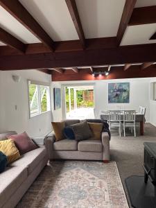 a living room with a couch and a table at Lake Okareka Calder Road Cottage in Rotorua
