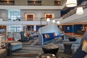 a lobby with couches and tables in a building at Renaissance Concourse Atlanta Airport Hotel in Atlanta