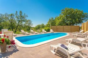 una piscina con sillas y un montón de plantas en Apartment Marinko, en Barban