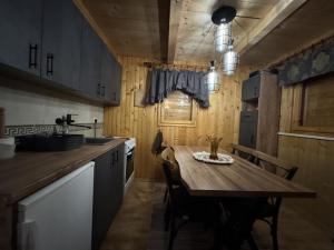une cuisine avec une table en bois et quelques chaises dans l'établissement Cottage Walnut, à Kolašin