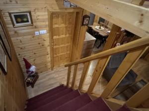 un chat assis sur une chaise dans une pièce avec des escaliers dans l'établissement Cottage Walnut, à Kolašin