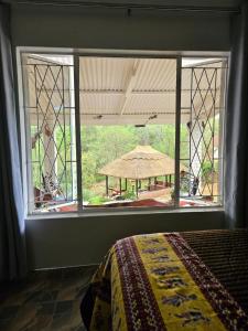 a bedroom with a window with a view of a yard at StoneWoodGrey in Harare