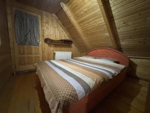 une chambre avec un lit dans une pièce en bois dans l'établissement Cottage Walnut, à Kolašin