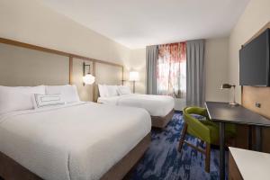 a hotel room with two beds and a desk at Fairfield Inn by Marriott Tracy in Tracy