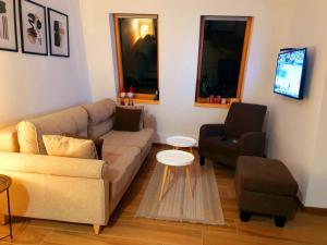 a living room with a couch and a chair at Apartment Holiday Ravna Planina in Pale +4 photos