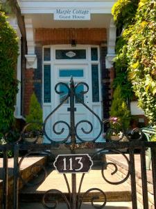 ein Schild vor der Haustür eines Hauses in der Unterkunft Marple Cottage Guest House in London