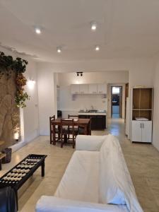 a living room with a white couch and a kitchen at Departamento Centrico SMA in San Martín de los Andes