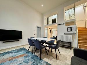 uma sala de jantar com mesa e cadeiras e uma TV em Future Apartments em Milão