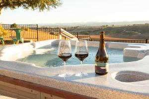 zwei Weingläser und eine Flasche Wein auf einem Whirlpool in der Unterkunft Kiler Ranch House & Apartment in Paso Robles