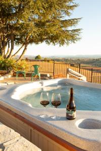 zwei Gläser Wein neben einem Whirlpool in der Unterkunft Kiler Ranch House & Apartment in Paso Robles