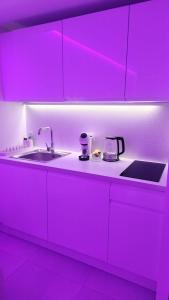 una cucina con lavello e illuminazione viola di Love room à 30 mn des plages et de Vannes a Questembert