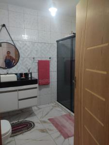 a bathroom with a shower and a person in a mirror at Cantinho da nete in Ilhéus