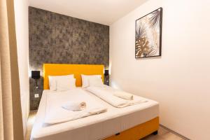 una camera da letto con un letto con lenzuola bianche di Sunset Resort 003 Jacuzzi a Fonyód