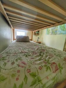 a bedroom with a bed with a floral bedspread at Casa Natales - Dormitorio Privado in Puerto Natales