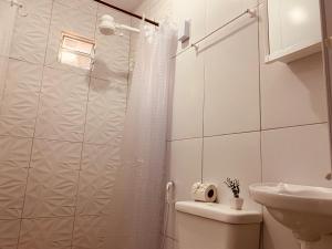 un bagno con doccia, WC e lavandino di Casa e Ktinetes na praia de Japaratinga a Japaratinga Altre 38 foto