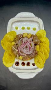 a plate of food with chips and meat and onions at Akwaba Lodge in The Gap