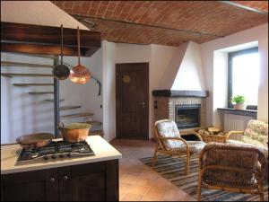 a kitchen with a stove and a living room at C dra Topia the Grape Pergola House near Alba Charming house - Italy in Trezzo Tinella