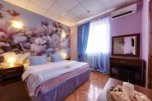 1 dormitorio con cama y pared de flores en Marton Amigo Krasnodar, en Krasnodar