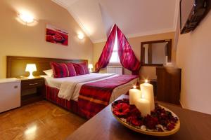 1 dormitorio con 1 cama y 2 velas en una mesa en Marton Amigo Krasnodar, en Krasnodar