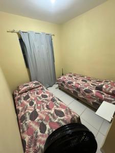1 dormitorio con 2 camas y cortina en Prive 3 quartos proximo a praia, en Paulista 3 fotos más