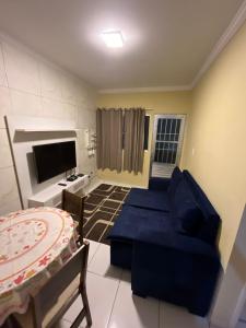 Una sala de estar con un sofá azul y un televisor. en Prive 3 quartos proximo a praia, en Paulista