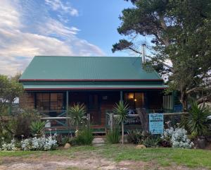 a house with a green roof and a sign in front of it at Banksia Views in Sandy Point
