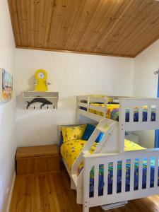 a bedroom with two bunk beds and a wooden ceiling at Banksia Views in Sandy Point
