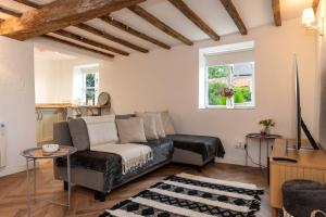 un salon avec un canapé et une table dans l'établissement Millbank Farm Cottage, à Stafford