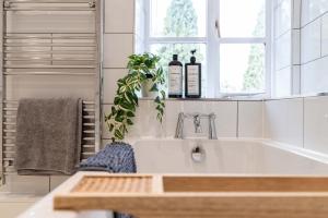 - une cuisine avec un évier et 2 bouteilles de vin dans l'établissement Millbank Farm Cottage, à Stafford 11 autres photos