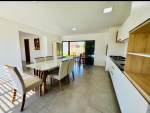 a kitchen and dining room with a table and chairs at Casa Atantida Sul in Osório